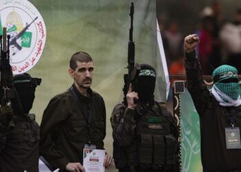 Combatientes palestinos del grupo Hamás escoltan a un rehén israelí antes de entregarlo a la Cruz Roja en Deir al-Balah, en el centro de Gaza, el 8 de febrero de 2025. Foto: Haitham Imad / EFE.