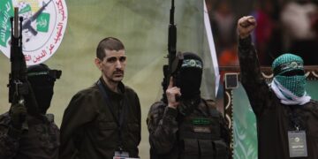 Combatientes palestinos del grupo Hamás escoltan a un rehén israelí antes de entregarlo a la Cruz Roja en Deir al-Balah, en el centro de Gaza, el 8 de febrero de 2025. Foto: Haitham Imad / EFE.