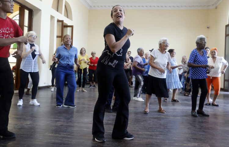 Lizt Alfonso (c) dirige una clase de baile para adultos mayores en La Habana, como parte de una iniciativa inspirada por la exposición "Abuelos y Abuelas prestados" de la fotógrafa cubana Monik Molinet. Foto: Ernesto Mastrascusa / EFE.