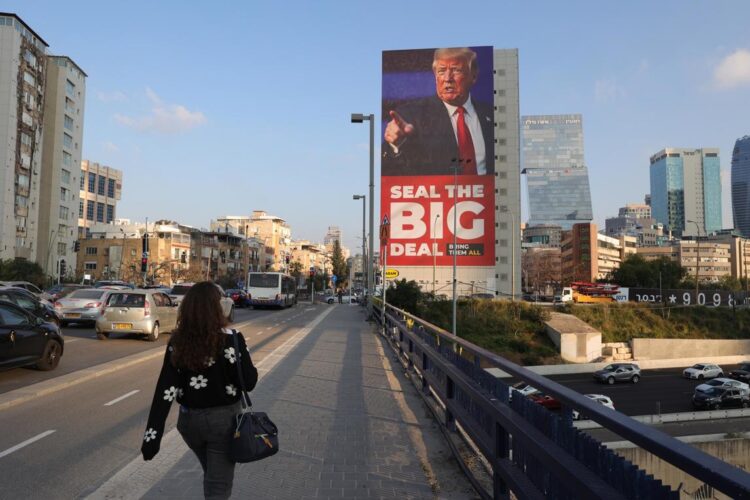 Tel Aviv (Israel), 04/02/2025. La gente pasa junto a un gran cartel que muestra al presidente estadounidense Donald Trump pidiendo completar el acuerdo sobre rehenes entre Israel y Hamás. Foto: EFE/EPA/ABIR SULTAN