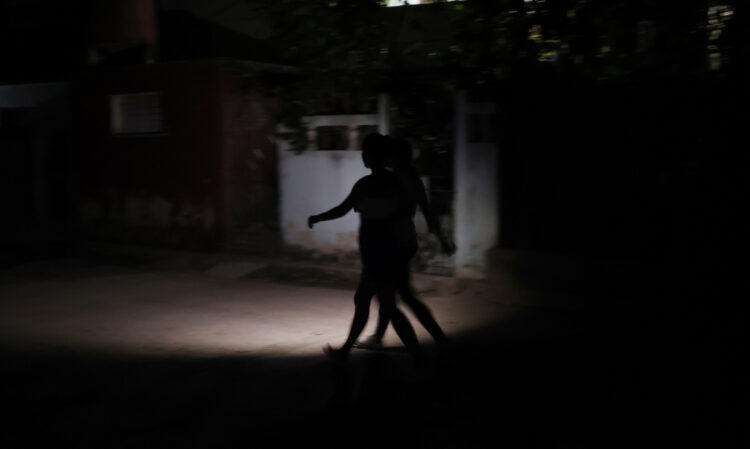 Personas caminan por una calle sin luz el sábado 15 de marzo de 2025, en La Habana, un día después del colapso del Sistema Eléctrico de Cuba. Foto: Ernesto Mastrascusa / EFE.