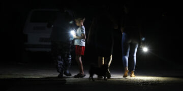 Personas caminan por una calle sin luz en La Habana, durante el apagón general por la desconexión del Sistema Eléctrico Nacional (SEN). Foto: Ernesto Mastrascusa / EFE.
