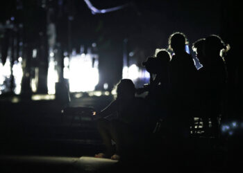 Personas esperan en una calle sin luz durante la caída del Sistema Eléctrico Nacional (SEN) en marzo pasado. EFE/ Ernesto Mastrascusa