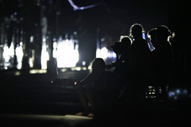 Personas esperan en una calle sin luz durante la caída del Sistema Eléctrico Nacional (SEN) en marzo pasado. EFE/ Ernesto Mastrascusa