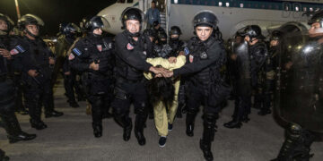 Fotografía cedida por la Presidencia de El Salvador donde se observa a policías de la Unidad de Mantenimiento del Orden (UMO) trasladando a supuestos miembros de la banda criminal conocida como Tren de Aragua el domingo 16 de marzo de 2025, en el aeropuerto internacional Óscar Arnulfo Romero, en San Luis Talpa, tras ser deportados desde Estados Unidos. Foto: Presidencia de El Salvador / EFE.