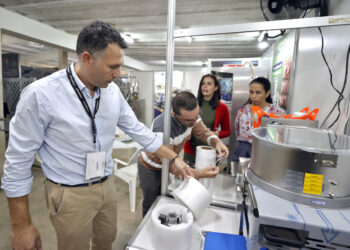 El presidente de la compañía chilena Envatek, José Saieh (i), revisa productos durante la XXVI Feria Internacional Agroindustrial Alimentaria (Fiagrop), en La Habana. Foto: Ernesto Mastrascusa / EFE.