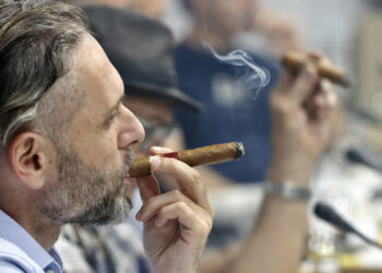 Participantes en la edición 35 del Festival del Habano fuman puros durante el evento. Foto: Ernesto Mastrascusa / EFE.