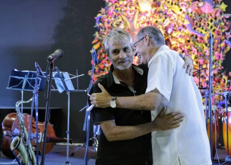 Edelmis Anoceto (izq), ganador del premio Casa de las Américas en la categoría de Cuento, es abrazado por Jorge Fornet, director del Centro de Investigaciones Literarias de esa institución cubana. Foto: Casa de las Américas / Facebook.