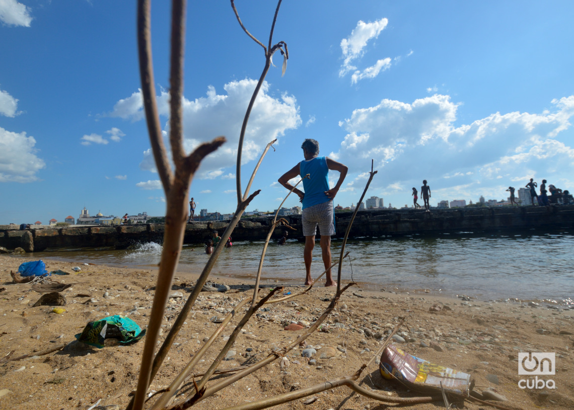 Una abuela vigila los movimientos de sus nietos en la playita del antiguo Muelle del Carbón, en Casablanca. Foto: Otmaro Rodríguez.