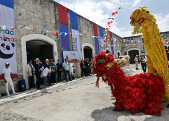 Personas observan figuras alusivas a la cultura China en la Feria Internacional de Turismo FitCuba 2025, en la fortaleza de La Cabaña, en La Habana. Foto: Ernesto Mastrascusa / EFE.