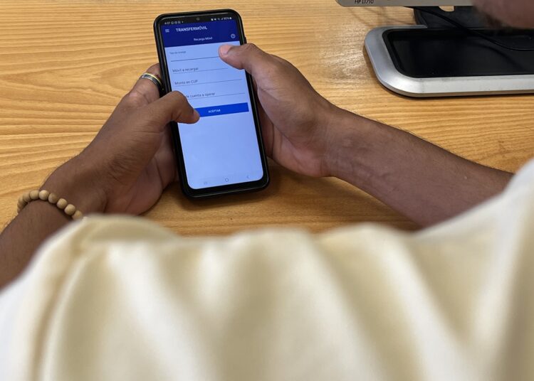 Joven realiza transferencia a través de Transfermóvil. Foto: OnCuba.