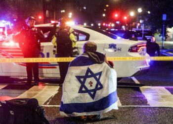 Un hombre con una bandera israelí sobre los hombros cerca del lugar donde dos personas fueron asesinadas cerca del Museo Judío, en Washington DC, el 22 de mayo de 2025. Foto: Will Oliver / EFE / EPA.