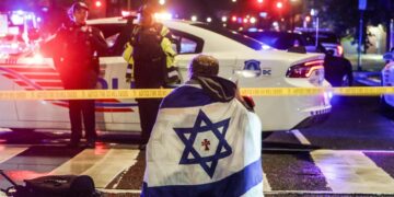 Un hombre con una bandera israelí sobre los hombros cerca del lugar donde dos personas fueron asesinadas cerca del Museo Judío, en Washington DC, el 22 de mayo de 2025. Foto: Will Oliver / EFE / EPA.