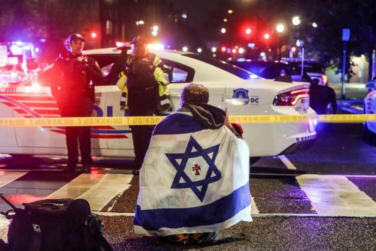 Un hombre con una bandera israelí sobre los hombros cerca del lugar donde dos personas fueron asesinadas cerca del Museo Judío, en Washington DC, el 22 de mayo de 2025. Foto: Will Oliver / EFE / EPA.