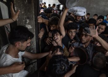 Cientos de palestinos esperan por una ración de comida en la ciudad de Gaza. Foto: FE/EPA/HAITHAM IMAD.