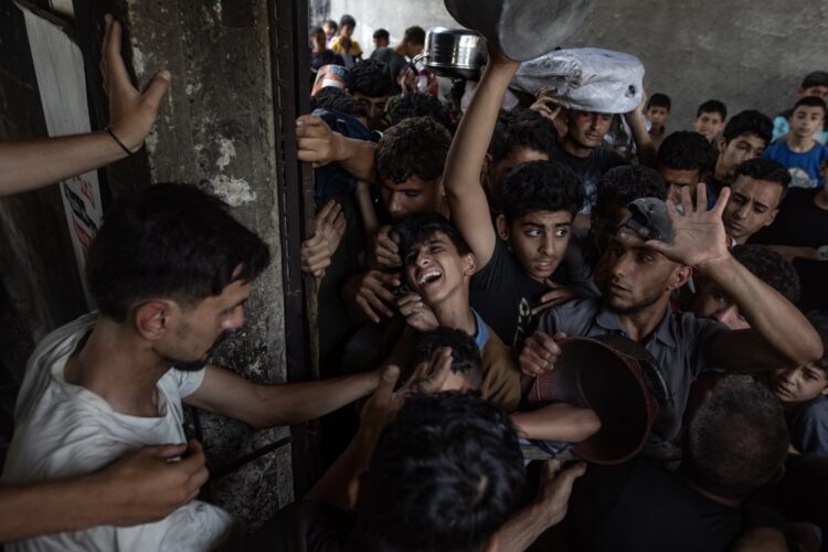 Cientos de palestinos esperan por una ración de comida en la ciudad de Gaza. Foto: FE/EPA/HAITHAM IMAD.