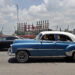 Autos transitan frente a las patanas turcas, generadoras de electricidad, desde la bahía de La Habana. Foto:  Ernesto Mastrascusa/EFE.