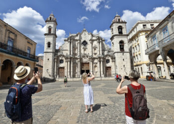 Turistas toman fotos de la catedral de La Habana este sábado en La Habana (Cuba). Foto: EFE/Ernesto Mastrascusa.