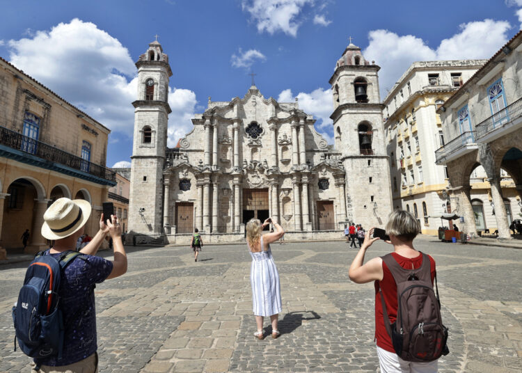 Turistas toman fotos de la catedral de La Habana este sábado en La Habana (Cuba). Foto: EFE/Ernesto Mastrascusa.