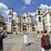 Turistas toman fotos de la catedral de La Habana este sábado en La Habana (Cuba). Foto: EFE/Ernesto Mastrascusa.