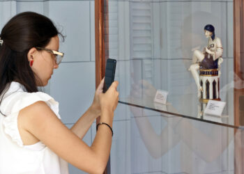 Una joven toma una fotografía en la exposición "De París a La Habana. Cien años de Art Déco", en el Museo Nacional de Artes Decorativas en La Habana. Foto: Ernesto Mastrascusa / EFE.