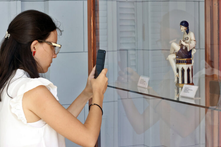 Una joven toma una fotografía en la exposición "De París a La Habana. Cien años de Art Déco", en el Museo Nacional de Artes Decorativas en La Habana. Foto: Ernesto Mastrascusa / EFE.