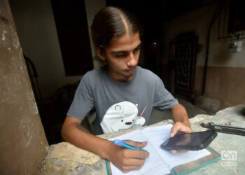 Un joven estudia usando la conexión a internet en su teléfono móvil, en La Habana. Foto: Otmaro Rodríguez.