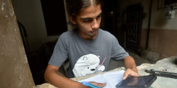 Un joven estudia usando la conexión a internet en su teléfono móvil, en La Habana. Foto: Otmaro Rodríguez.
