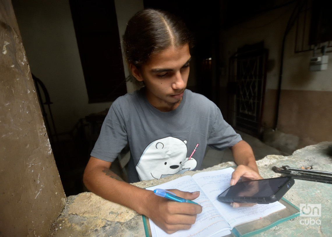 Un joven estudia usando la conexión a internet en su teléfono móvil, en La Habana. Foto: Otmaro Rodríguez.