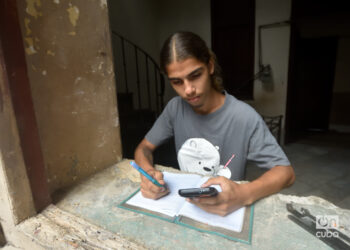 Un joven cubano estudia usando la conexión a internet en su teléfono móvil, tras el anuncio de las nuevas tarifas de Etecsa. Foto: Otmaro Rodríguez.
