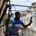 Un hombre se comunica a través de su teléfono celular en el balcón de una vivienda en La Habana, por existir allí mejor señal que en el interior de la casa. Foto: Otmaro Rodríguez.