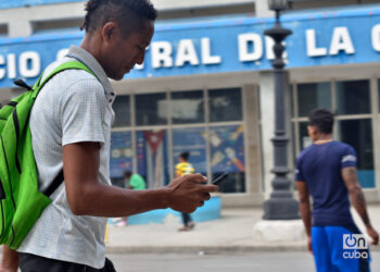 Un hombre revisa su teléfono celular en La Habana, luego del anuncio de las nuevas tarifas de Etecsa. Foto: Otmaro Rodríguez.