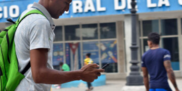 Un hombre revisa su teléfono celular en La Habana, luego del anuncio de las nuevas tarifas de Etecsa. Foto: Otmaro Rodríguez.