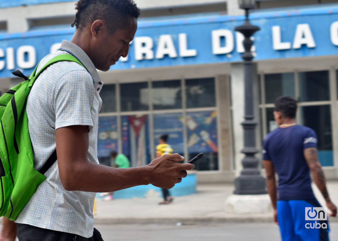 Un hombre revisa su teléfono celular en La Habana, luego del anuncio de las nuevas tarifas de Etecsa. Foto: Otmaro Rodríguez.