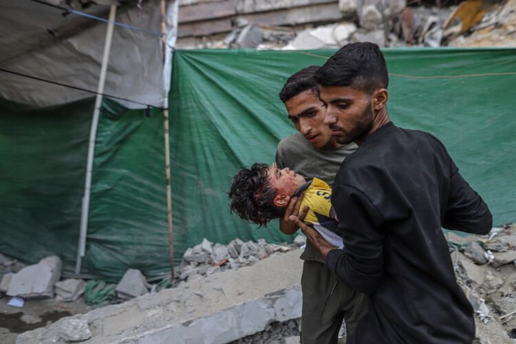 Dos palestinos cargan a un niño herido tras un ataque aéreo israelí en el barrio de Al Remal, en la ciudad de Gaza, al norte de la Franja, el 3 de junio de 2025. Foto: EFE/EPA/MOHAMMED SABER.
