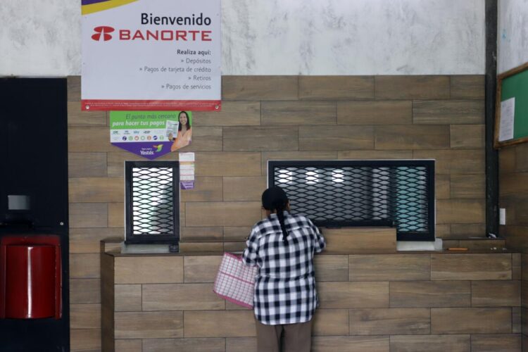 Una mujer que retira su dinero en una casa de cambio en el municipio de Tepeojuma (México). Foto: EFE/Hilda Ríos.