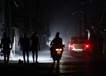 Varias personas circulan por una calle durante un apagón en Pinar del Río. Foto: EFE/ Ernesto Mastrascusa.