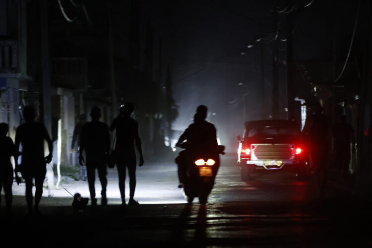 Varias personas circulan por una calle durante un apagón en Pinar del Río. Foto: EFE/ Ernesto Mastrascusa.