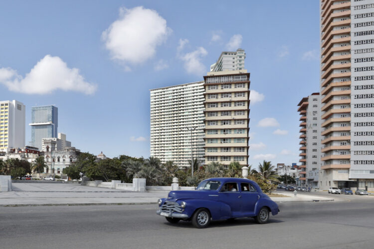 Un auto clásico transita cerca de varios edificios, en el Vedado habanero. Foto: Ernesto Mastrascusa / EFE / Archivo.