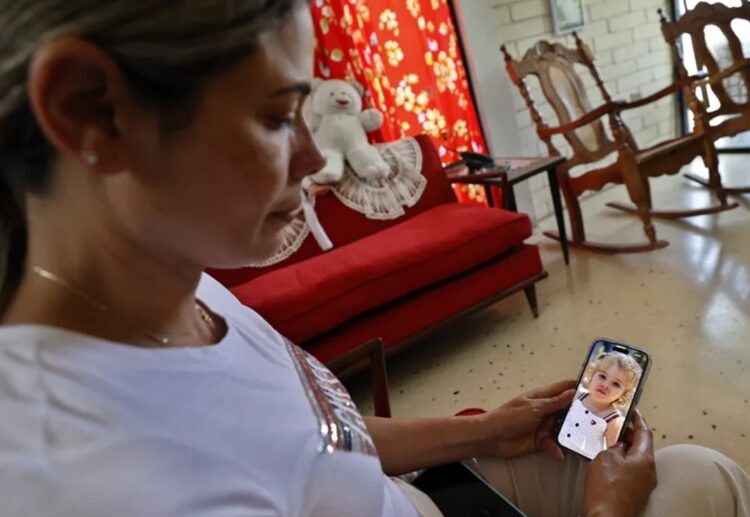Heidy Sánchez, cubana deportada desde Estados Unidos, observa una foto de su hija durante una entrevista con EFE, en La Habana. Foto: Ernesto Mastrascusa / EFE / Archivo.