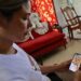 Heidy Sánchez, cubana deportada desde Estados Unidos, observa una foto de su hija durante una entrevista con EFE, en La Habana. Foto: Ernesto Mastrascusa / EFE / Archivo.