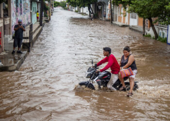Un motociclista circula por una calle inundada tras el paso del huracán Erick. Foto: Luis Villaobos/EFE.