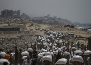 Palestinos cargan sacos de harina de trigo este 27 de julio en una de las pausas del genocidio israelí. Foto: EFE/EPA/MOHAMMED SABER