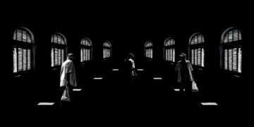 “Los bordes del tiempo”, 2023. Remedios, Cuba. Composición Digital. Escena construida desde la oscuridad en la que el espacio no está dado, sino inventado. Una misma ventana repetida con precisión, delimita el campo que solo existe en la lógica interna de la imagen; solo la geometría de la luz insinúa la arquitectura posible. En el centro de este bucle inquieto, la figura de un hombre introduce el tiempo, pero no lo libera. La atmósfera de la obra pertenece al terreno de lo onírico.