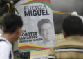 Personas orando por el senador Miguel Uribe ante un altar improvisado. Foto: EFE/ Carlos Ortega.