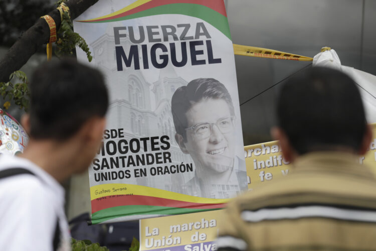 Personas orando por el senador Miguel Uribe ante un altar improvisado. Foto: EFE/ Carlos Ortega.