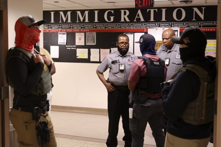 Agentes federales encapuchados hablan con encargados de seguridad mientras controlan audiencias judiciales en el Jacob K. Javits Federal Building, Nueva York, 14 de julio de 2025. Foto: EFE/EPA/SARAH YENESEL.