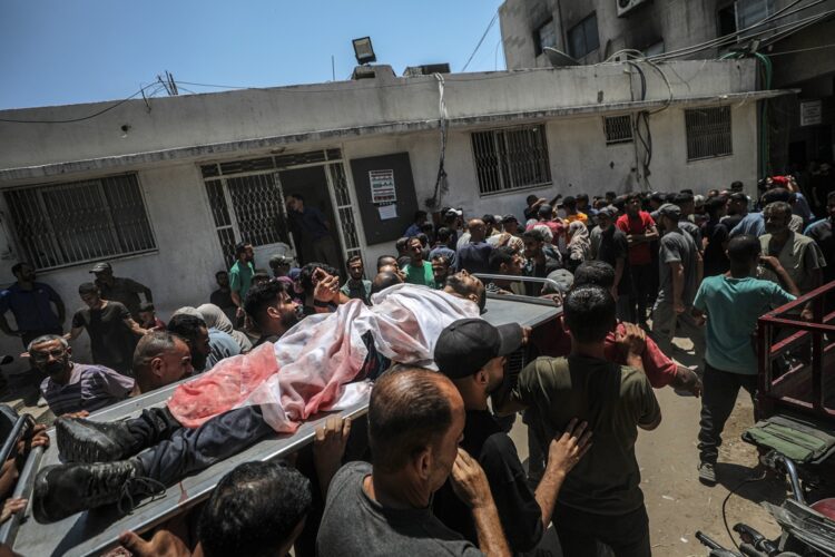 Palestinos cargan el cuerpo de un hombre asesinado a tiros por el Ejército de Israel en un punto de distribución de alimentos en Gaza, el 20 de julio de 2025. Foto: Mohammed Saber / EFE / EPA.
