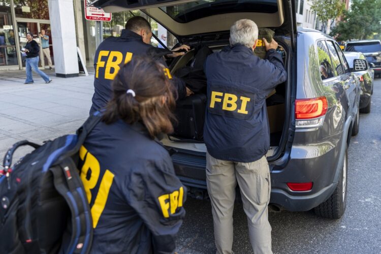 Agentes del FBI con documentos en poder de Jonh Bolton, exasesor de Seguridad Nacional del presidente Trump.  Foto: EFE/EPA/SHAWN THEW.