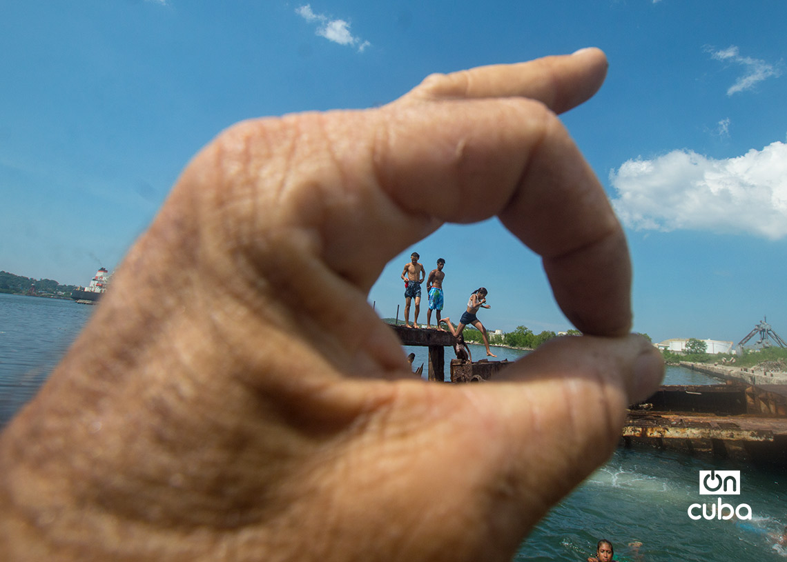 Niños y jóvenes bañándose en una piscina improvisada en una antigua patana en la bahía de La Habana, en Regla. Foto: Otmaro Rodríguez.